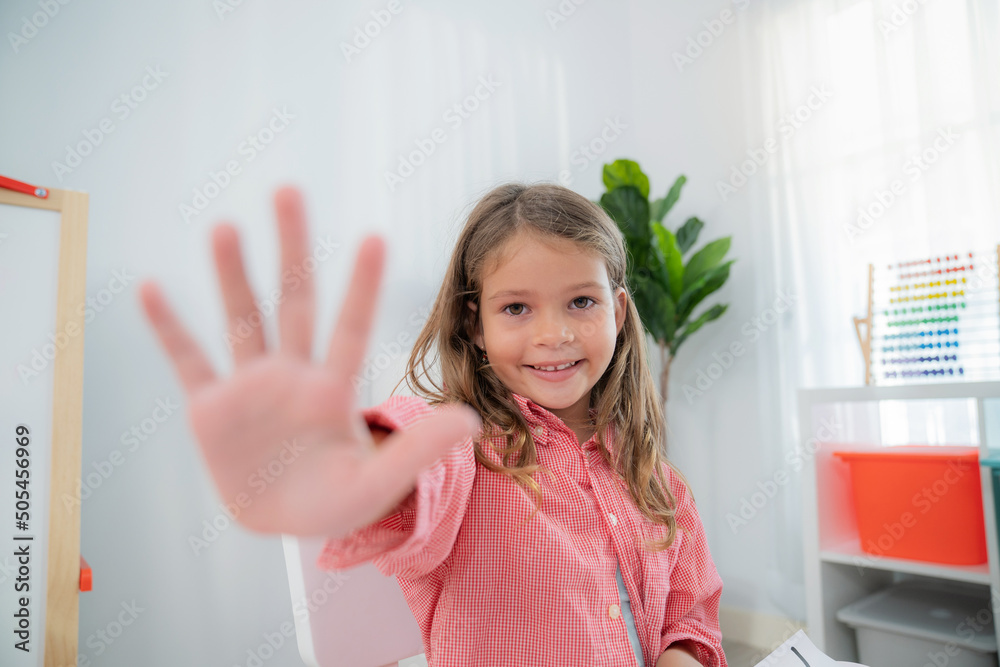 Pretty girls sitting in the kindergarten school classroom and showing hi five to teacher during classroom with smile. Learning, enjoy, education, playing concept. Feeling happy and fun Pretty girls sitting in the kindergarten school classroom and showing hi five to teacher during classroom with smile. Learning, enjoy, education, playing concept. Feeling happy and fun