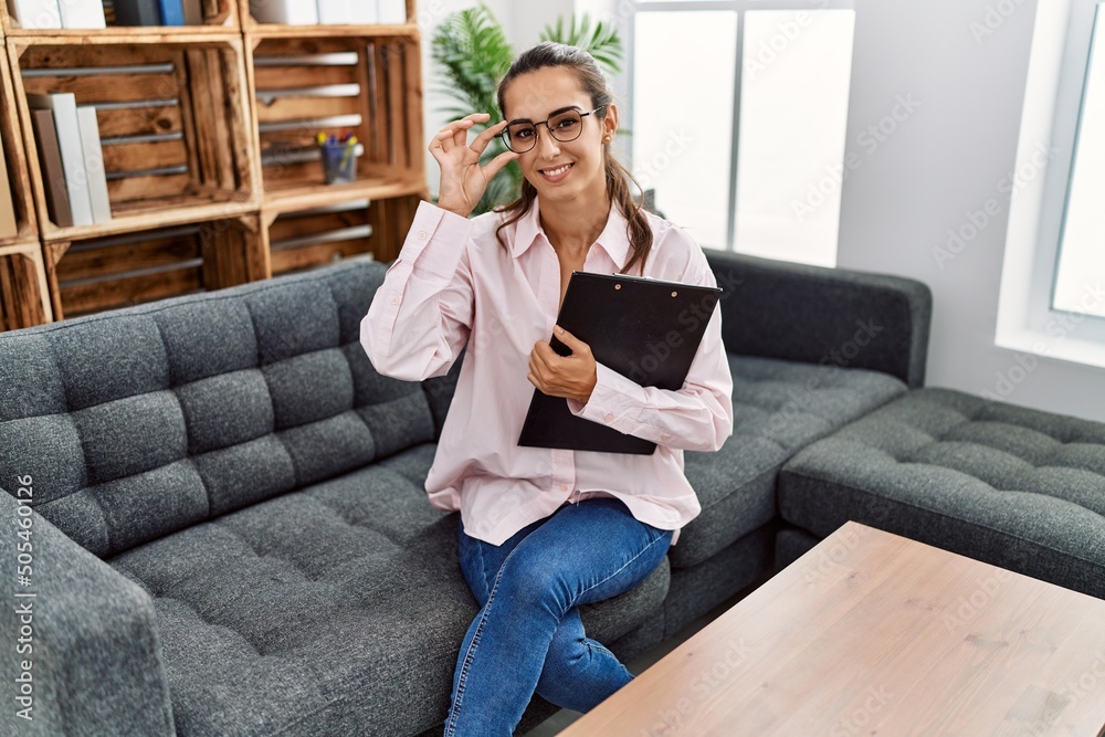 Young hispanic woman smiling confident having psychologist session at clinic Young hispanic woman smiling confident having psychologist session at clinic