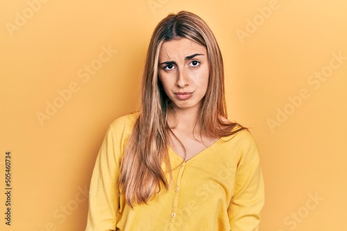 Beautiful hispanic woman wearing casual yellow sweater skeptic and nervous, frowning upset because of problem. negative person. © Krakenimages.com