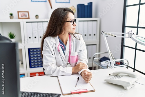 Young doctor woman wearing doctor uniform and stethoscope at the clinic looking to side  relax profile pose with natural face with confident smile.