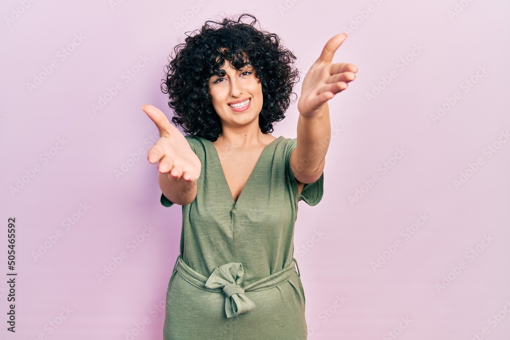 Young middle east woman wearing casual clothes looking at the camera smiling with open arms for hug. cheerful expression embracing happiness. Young middle east woman wearing casual clothes looking at the camera smiling with open arms for hug. cheerful expression embracing happiness.