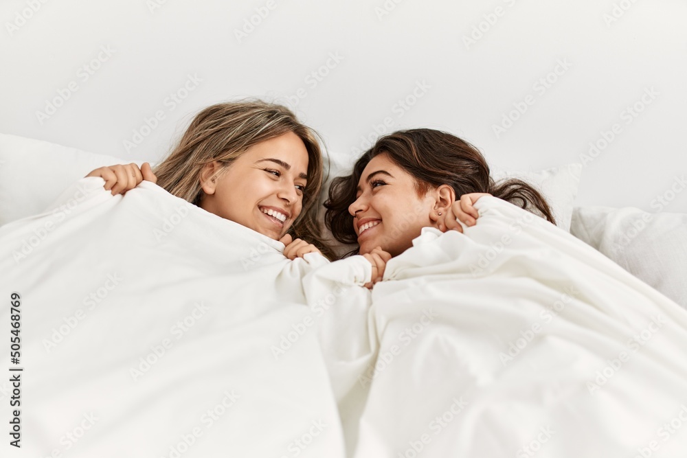 Young beautiful couple lying in bed and covering with blanket at home. Young beautiful couple lying in bed and covering with blanket at home.