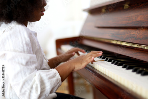 Beautiful little African American girl smile happy playing and learning piano classroom in holiday weekend at home.
