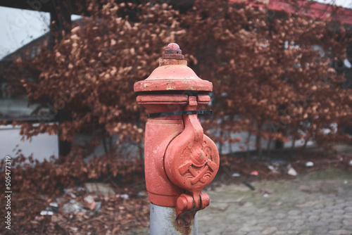 Closeup shot of an old red fire hydrant on a blurry background photo