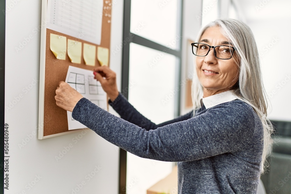 Middle age grey-haired woman business worker standing at office Middle age grey-haired woman business worker standing at office