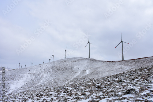 windmills over hill in snowy winter © 7