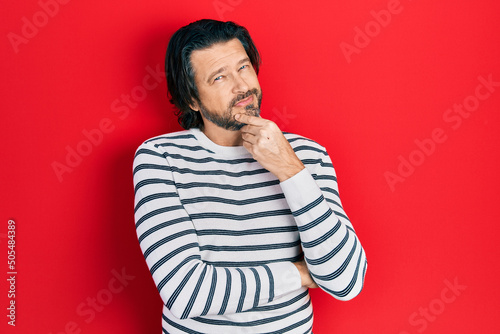 Middle age caucasian man wearing casual clothes smiling looking confident at the camera with crossed arms and hand on chin. thinking positive.