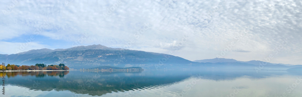 Panoramic view of calming Pamvotida Lake with reflection in Ioannina, Greece 