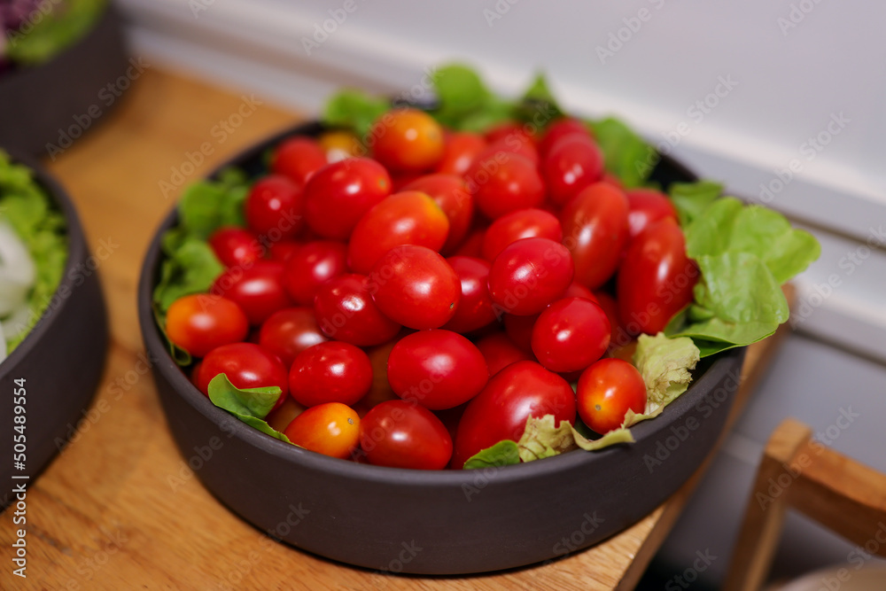 Closeup Cherry Tomatoes with salad on black bowl Closeup Cherry Tomatoes with salad on black bowl