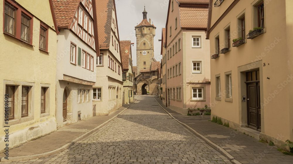 Rothenburg, Franconia / Germany - May 05. 2022: Cobblestone street in historic Rothenburg ob der Tauber with a view of the Klingenturm on the city walls