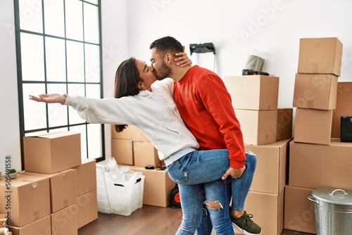 Young latin couple kissing and dancing at new home © Krakenimages.com