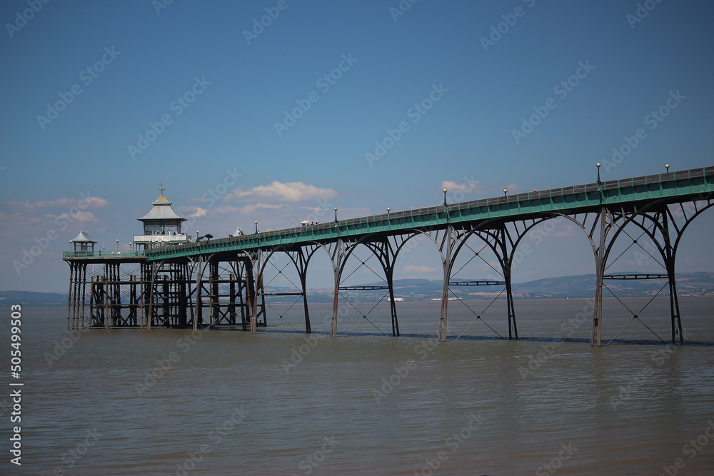 Clevedon pier putside of Bristol in South West England under the scorching sun on a clear summers day as the river servern lazily flows by