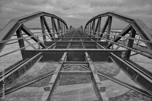 Grayscale shot of the Domitz Railway Bridge against the sky. Domitz, Germany. photo