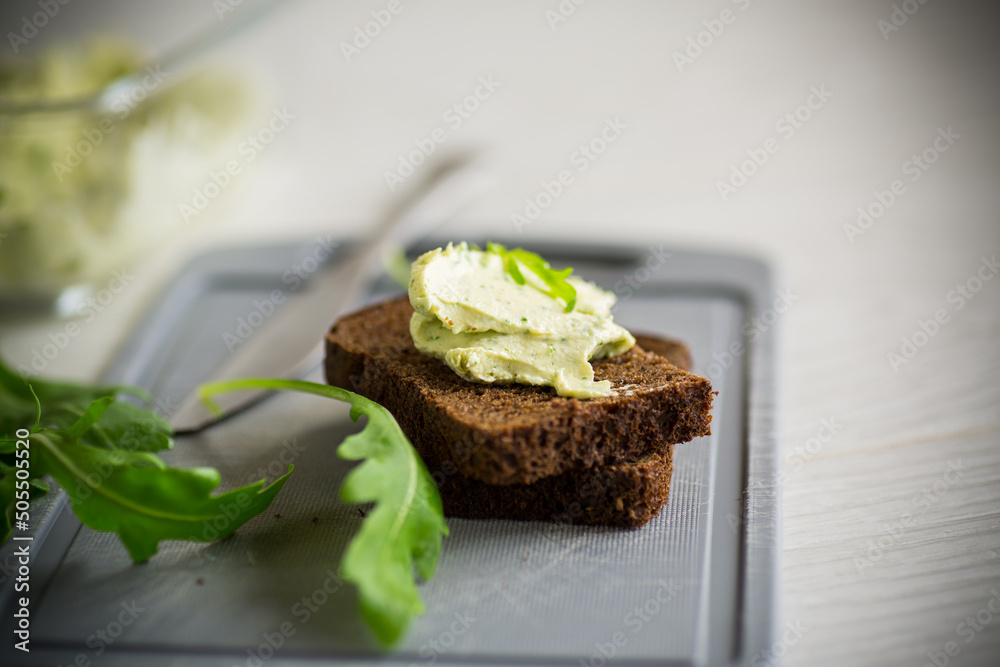 bread cheese spread with garlic and arugula on dark bread bread cheese spread with garlic and arugula on dark bread