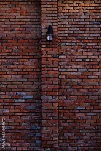 Street lamp on red, old brick wall.