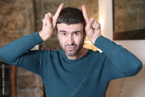 Man pretending to have horns