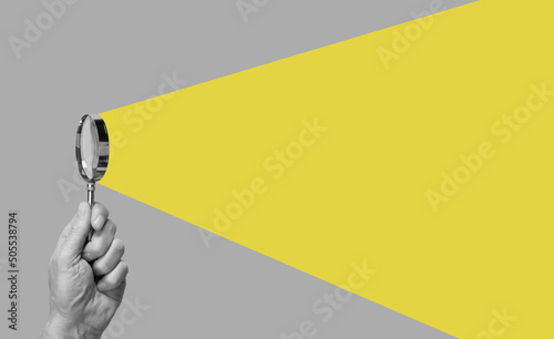 Man hand with magnifying glass. Yellow ray coming from loupe. Conducting check, information search and analysis concept. Spy, accountant, auditor job in abstract style. High quality photo photo