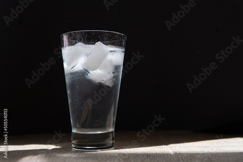 glass of water with ice on a black background