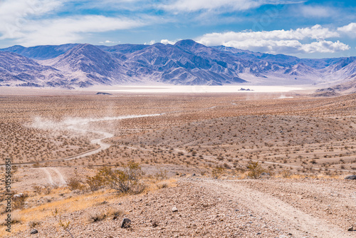 Vehicles travel down the gravel road towards the Racetrack Playa in Death Val...