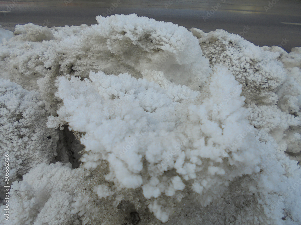Massive heap of snow dirty from fumes piled up next to the road and covered by beautiful hoarfrost ice crystal structures resembling corals. Massive heap of snow dirty from fumes piled up next to the road and covered by beautiful hoarfrost ice crystal structures resembling corals.