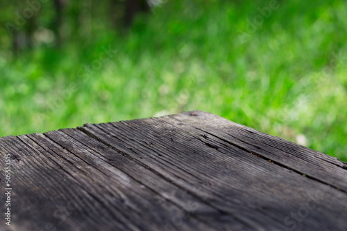 weathered wooden table with unfocused nature background