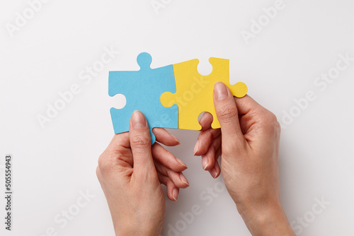 Ukrainian colors puzzle pieces in woman's hands