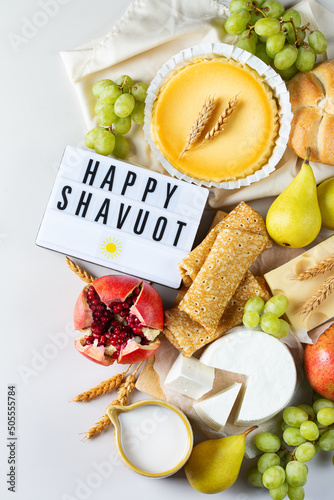 Jewish religious holiday Shavuot with dairy products, cheesecake, pancakes, fruits photo