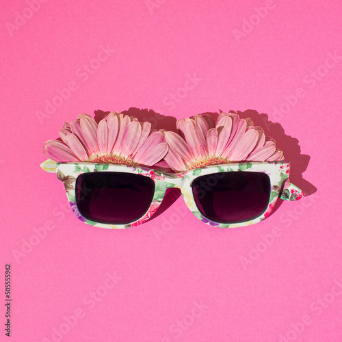 Bloosoming sunglasses on a pink background.Top view photo