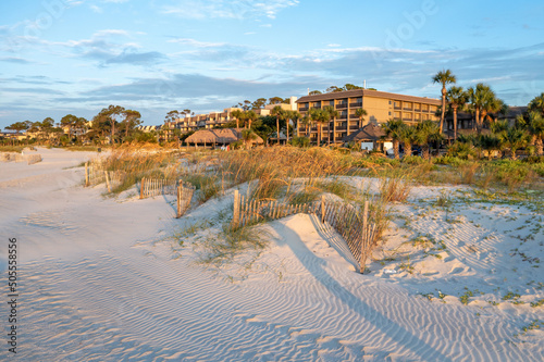 Photo of a building complex located behind sandy dunes and fencing at beach of Hilton Head Island photo