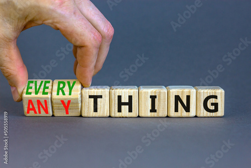 Anything or everything symbol. Businessman turns cubes and changes the concept word Anything to Everything. Beautiful grey background. Business motivational anything or everything concept. Copy space. photo