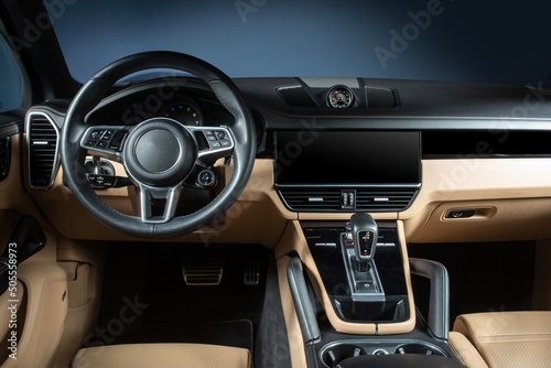 Modern car interior. White leather seats and dashboard multimedia inside modern SUV. View on the driver panel from the rear seat row. Expensive a luxury car inside