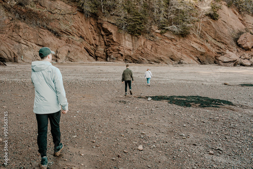 Back shot of three people walking in the Hopewell Rocks Provincial Park in New Brunswick, Canada