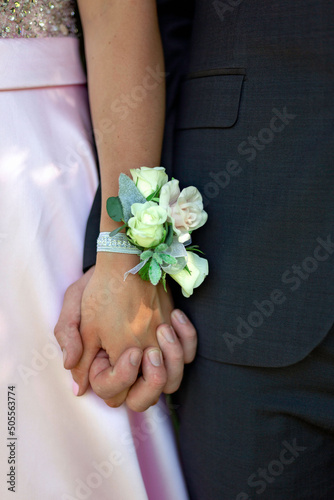Canvas Print Closeup up shot of a couple holding hands with a wrist corsage at their prom wit