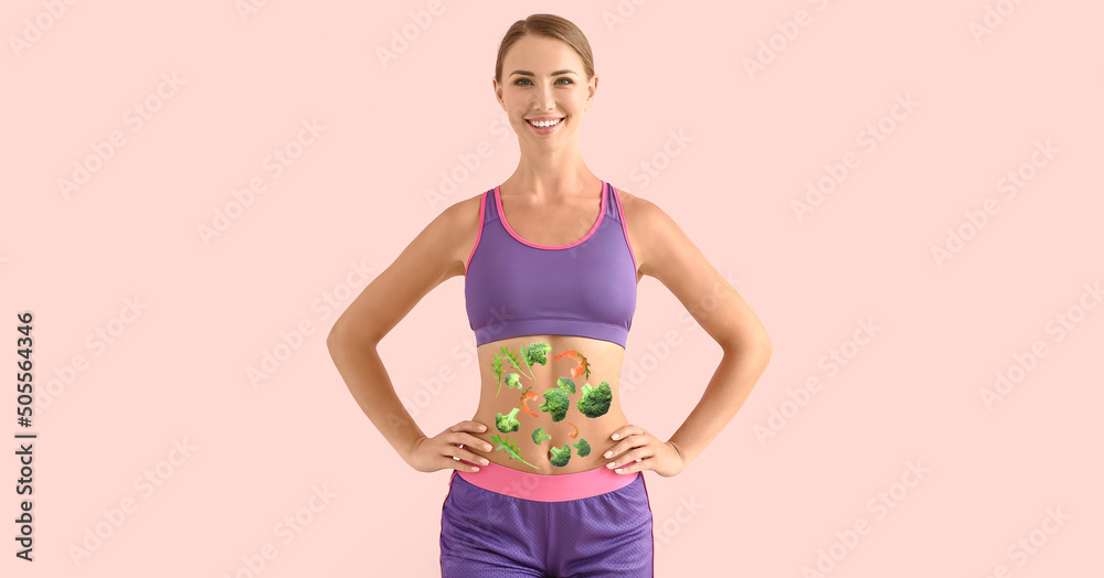 Φωτογραφία Sporty young woman with healthy products on her body against pink background