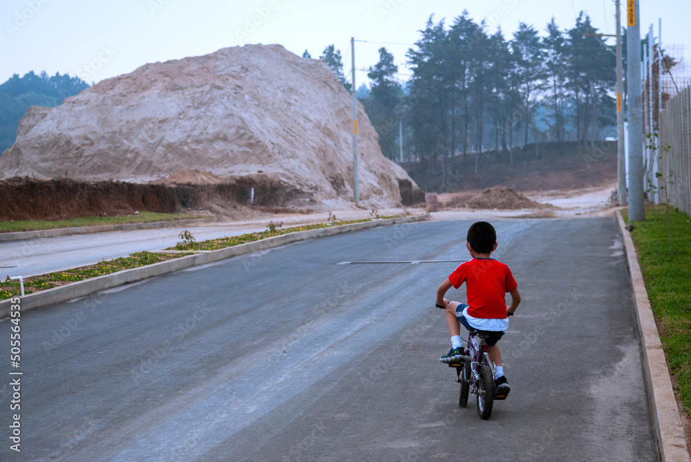 Φωτογραφία Child riding a bicycle outdoors on a paved road, children in the open air, healthy sport in times of COVID-19