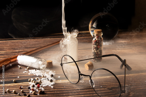 Small glasses with cork stopper with spices and empty  smoke  and more accessories  black background  selective focus.