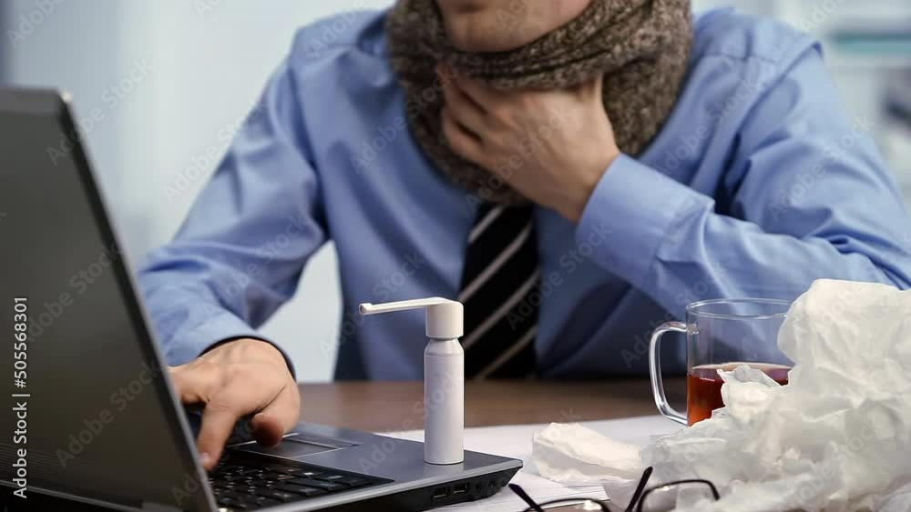 Throat Pain. Sick worker using spray for throat. Young man working in office suffering virus of flu, works on his laptop in the office. Throat Pain. Sick worker using spray for throat. Young man working in office suffering virus of flu, works on his laptop in the office.