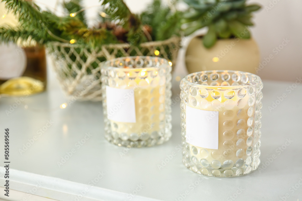 Holders with burning candles on table, closeup