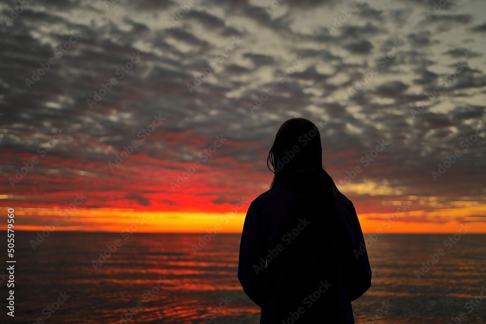 A Young Adolescent Girl Looks in Awe, Wonder, and Admiration at a Magnificent Sunset Sky