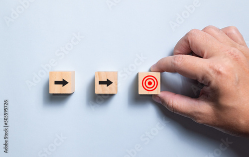 Top view wooden blocks set to step with icon arrow to target. Concept for growth business and targeting.