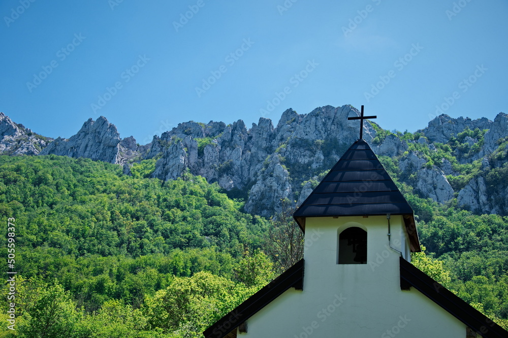 Closeup of church steeple against rocky landscape