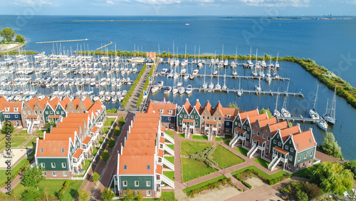 Aerial drone view of typical modern Dutch houses and marina in harbor from above, architecture of port of Volendam town, North Holland, Netherlands photo