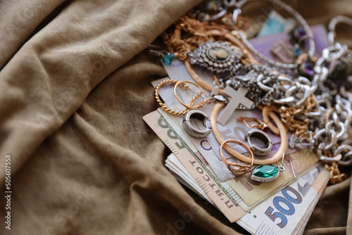 Fototapeta Bunch of stolen jewelry and money on military uniform cloth fabric