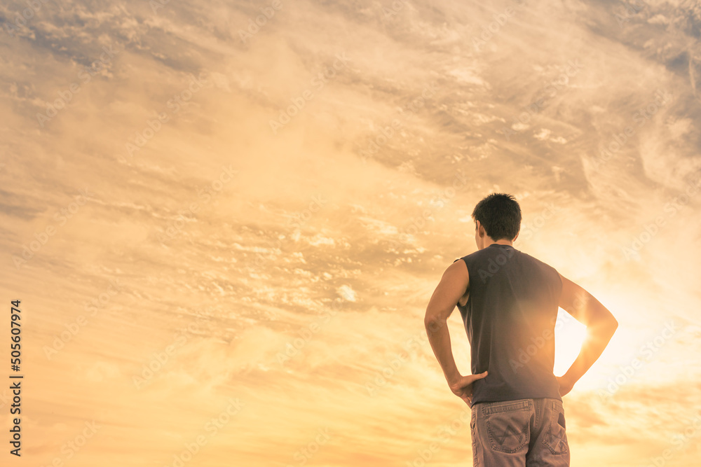 silhouette of young man standing facing the sunrise silhouette of young man standing facing the sunrise