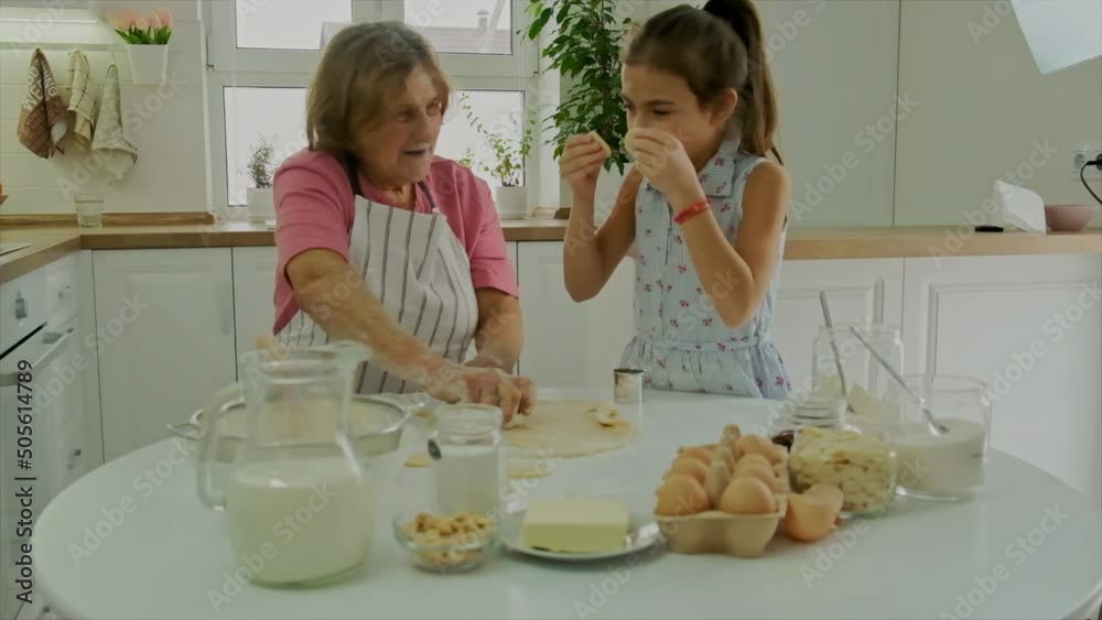 Grandmother and child cook dough together. Selective focus. Grandmother and child cook dough together. Selective focus.