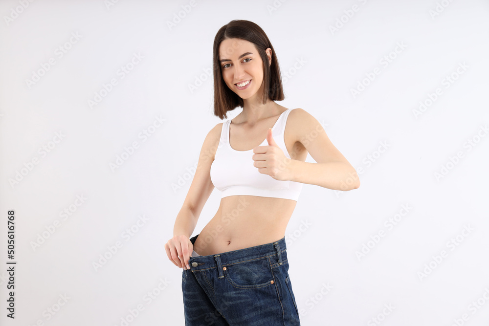 Concept of weight loss with thin girl on light background Concept of weight loss with thin girl on light background
