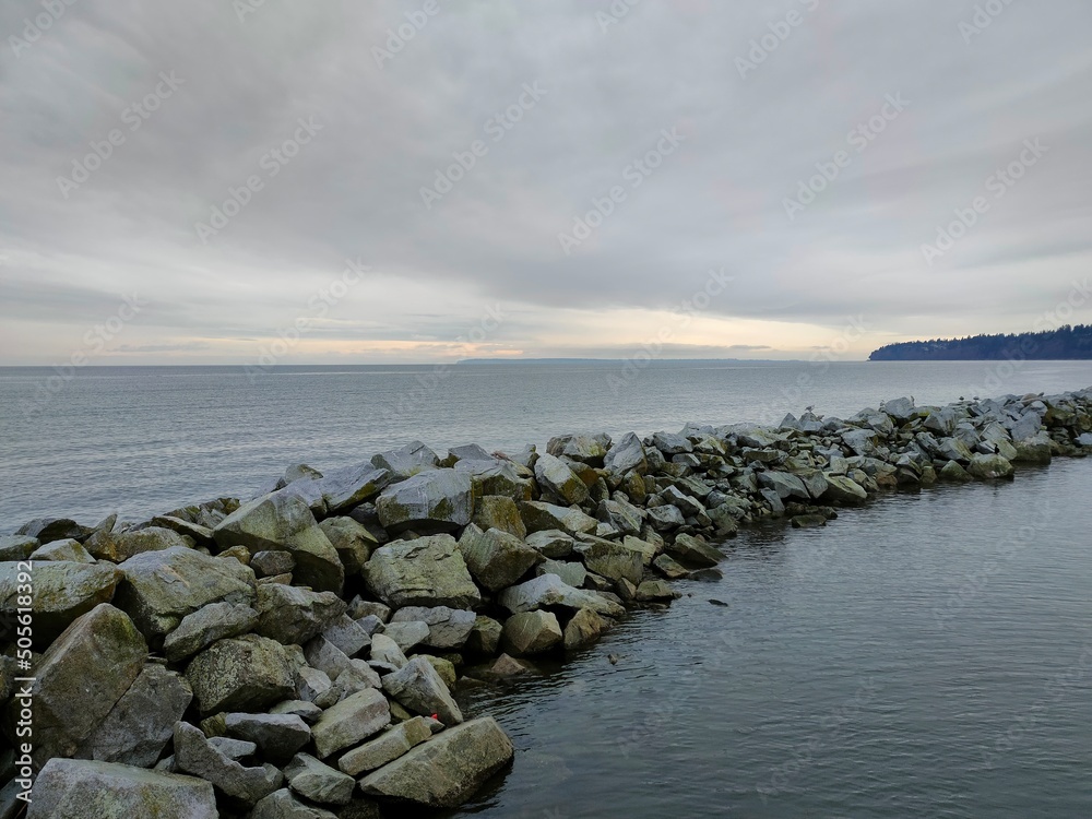 sea and rocks under cloudy sky sea and rocks under cloudy sky