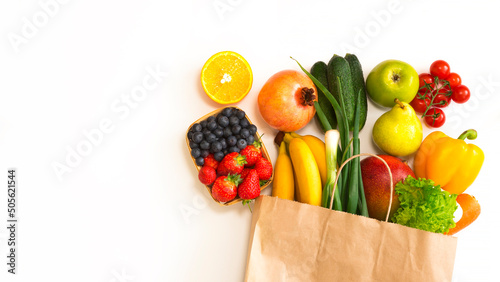 Fototapeta Naklejka Na Ścianę i Meble -  Paper bag with fruits and vegetables lies on a white background