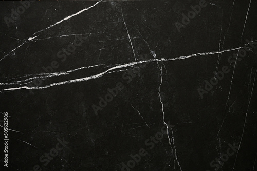 Black marble texture pattern. Black marble background with white veins © Tatsiana