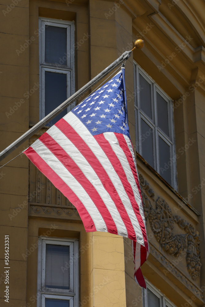 The national flag of the United States on the background of the embassy building in Moscow. The American national flag is waving in the wind. American Flag on a building. 